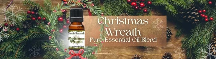 Christmas Wreath essential oil blend by Miracle Botanicals, with christmas wreaths and snowflakes in the background