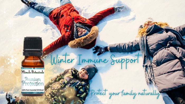 A family of three laying in the snow making snow angels, with an amber bottle of Premium Protection essential oil blend for immune support, an alternative to Thieves essential oil blend, and the words "Winter Immune Support... Protect your family naturally"