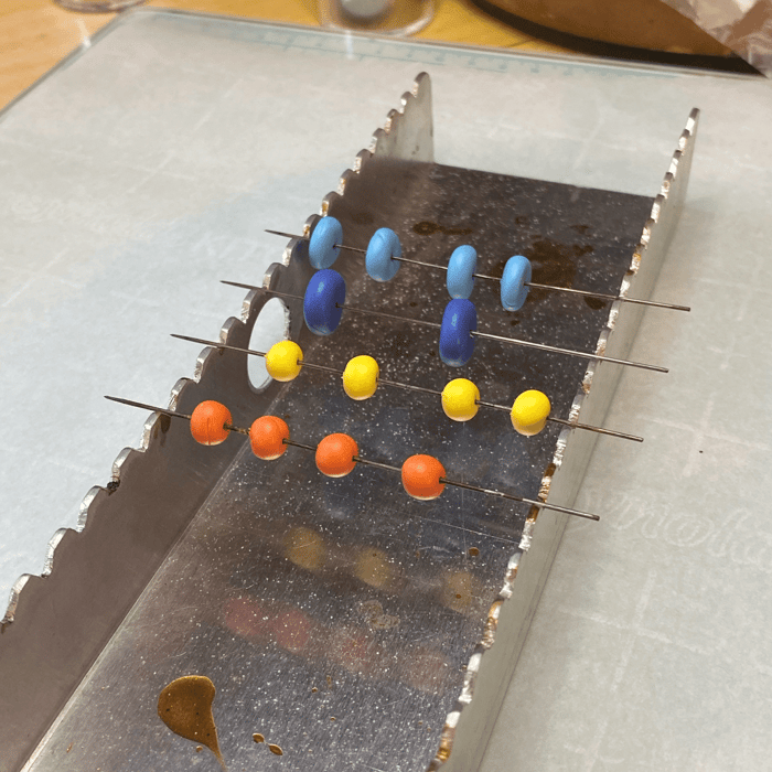 Polymer Clay beads on pins, ready for the oven