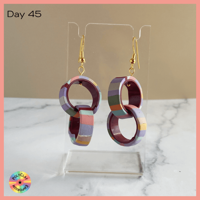 Double Hoop polymer clay earrings, striped outside, dark crimson inside.
