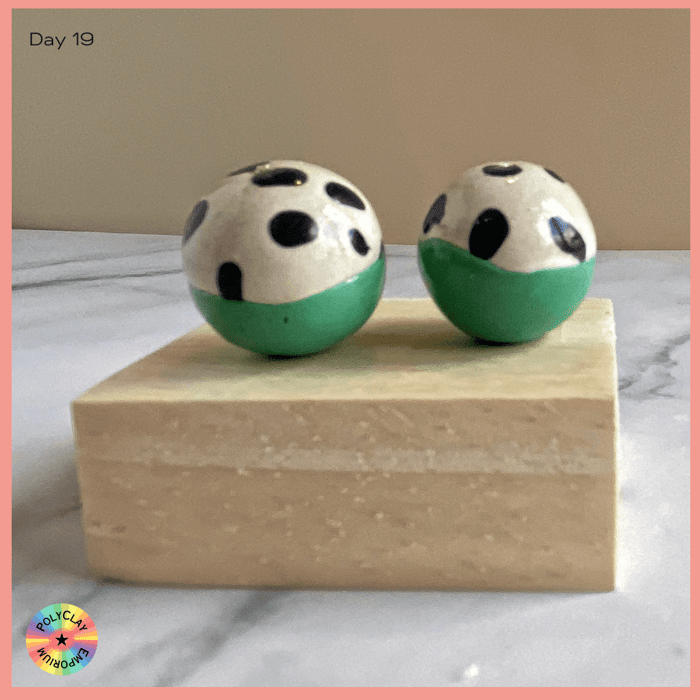 Polymer clay beads, top half white with black dots, bottom solid green.