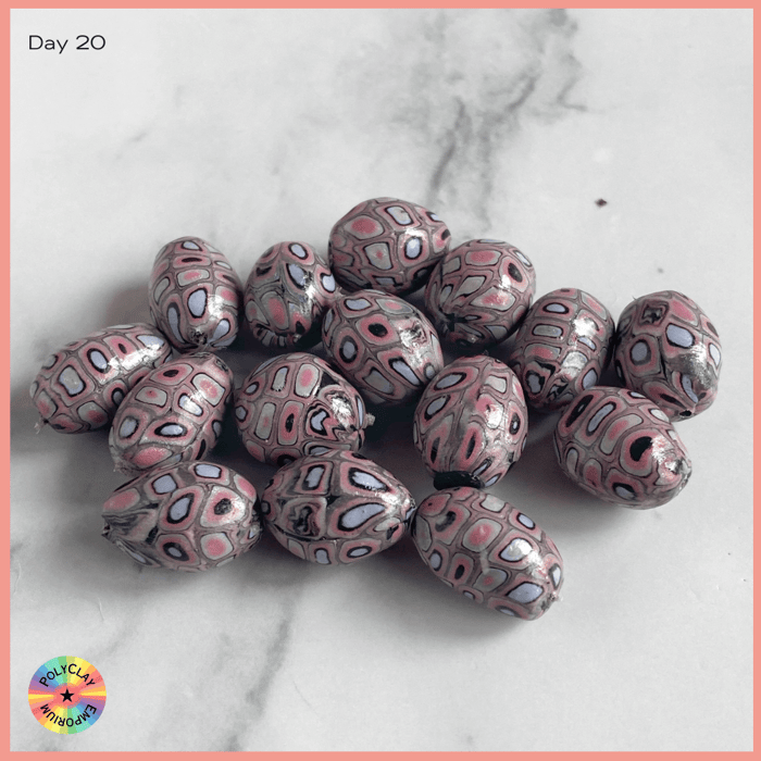 Extruded polymer clay rectangles in pinks and purples made into beads.