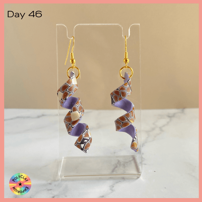 Polymer clay spiral earrings, brown toned slab on the outside, bright lavender on the inside
