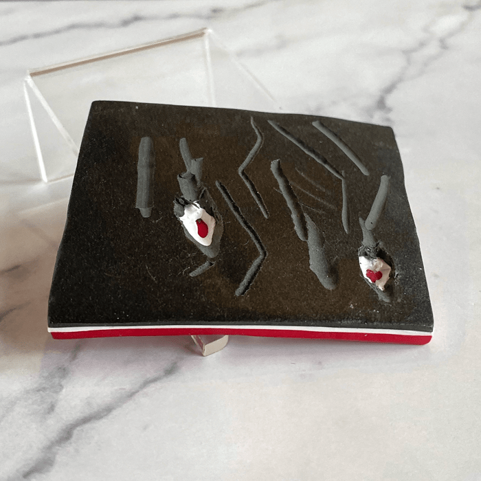 Only with great effort are little bits of the red and white underlayers revealed