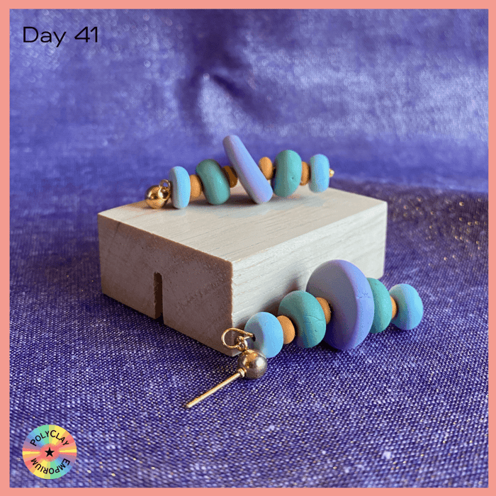 Blue toned polymer clay cairn earring with orange separaters