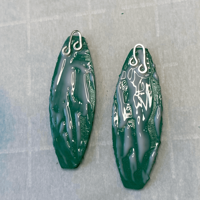 The backs of the earrings, coated with polymer clay adhesive, ear wires in place