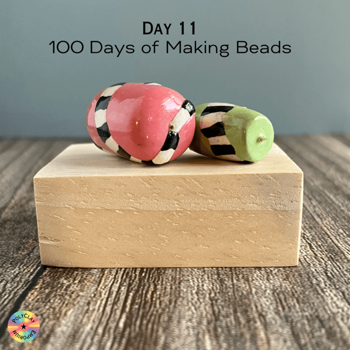 A coral and a green polymer clay bead with black and white decorations