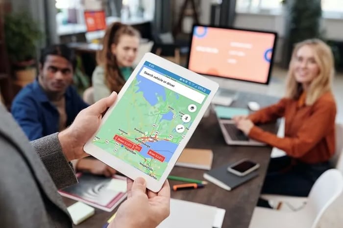 Manager meeting with employees with Trackem open on a tablet