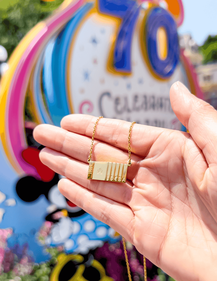 Ticket to Magic Necklace in Front of Disneyland's 70th Anniversary Decorations