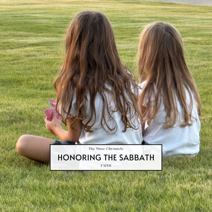 Two young girls sitting together on green grass at sunset, symbolizing peace, family, and faith as part of a story on honoring the Sabbath.