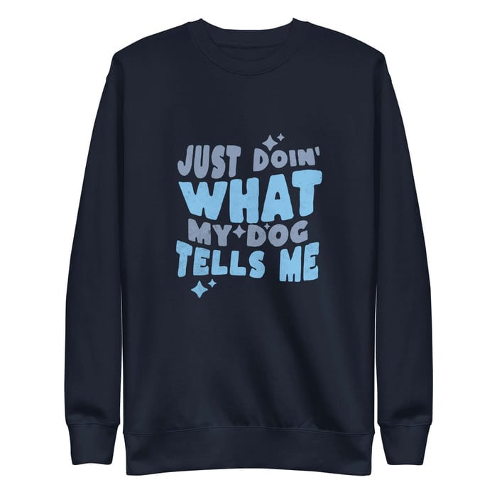 Navy crewneck sweatshirt with blue and slate “Just Doin’ What My Dog Tells Me” graphic and star accents on a white background.