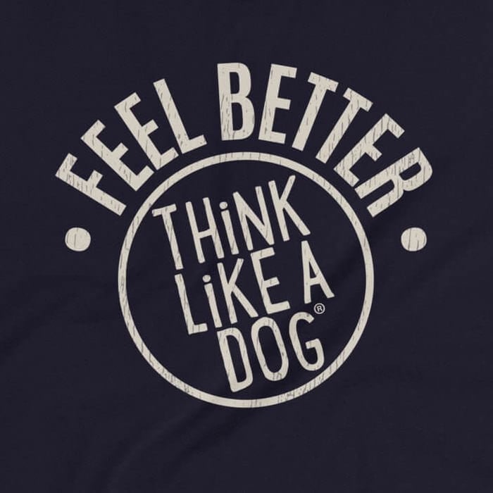 Close-up of a t-shirt design featuring the phrase 'FEEL BETTER' in bold, distressed text above a circular THiNK LiKE A DOG® logo. The light tan text stands out against the dark background, creating a clean and motivational design.