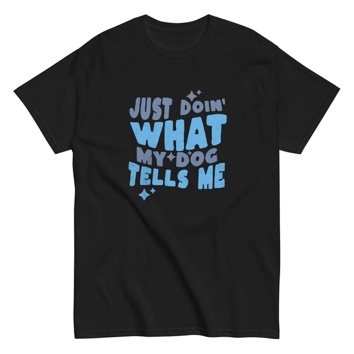 Black graphic T-shirt with blue “Just Doin’ What My Dog Tells Me” lettering and star accents on a plain white background.