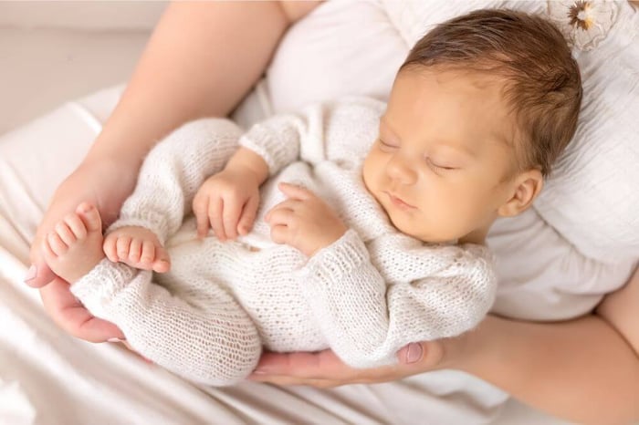 Newborn sleeping with arms raised showing normal sleep position