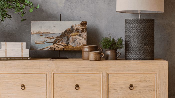 A set of stacked bone inlay boxes with antique artwork displayed on an easel.