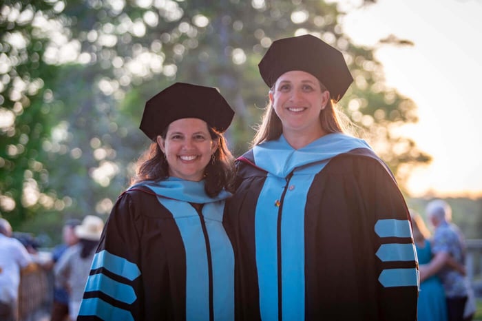 EmpowerEdD - Two doctoral grads in cap and gown