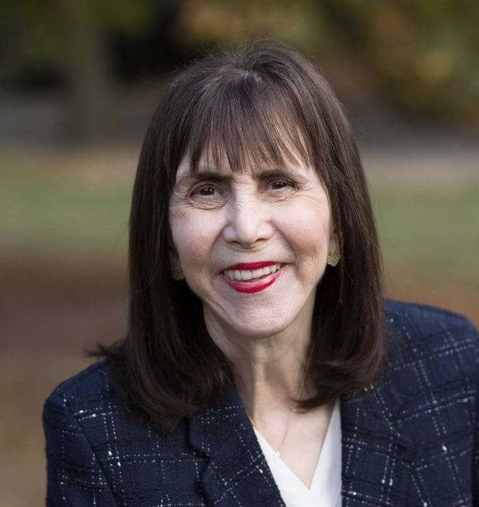 Dr. Wepner headshot with navy blazer and blurred green background
