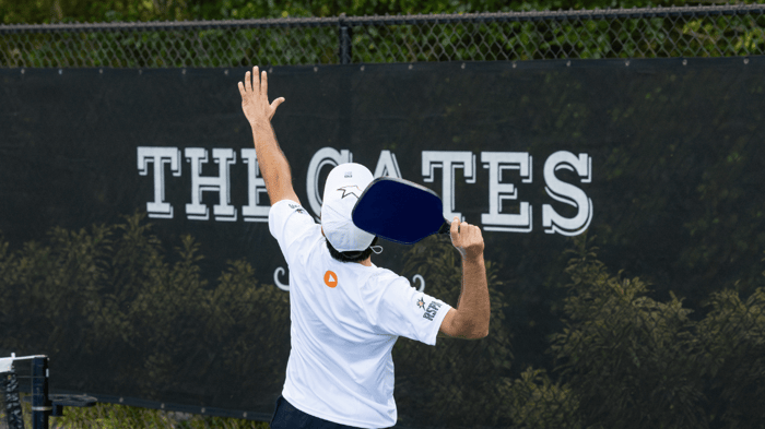 Player hitting a pickleball on a court