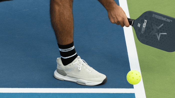 Pickleball player hitting a pickleball on a court