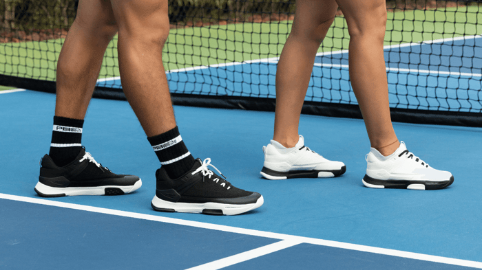 Pickleball players standing on a court, facing right