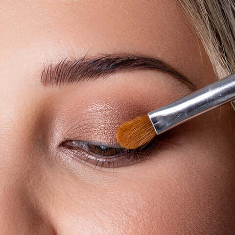 Eye shadow being applied to a models eye. 