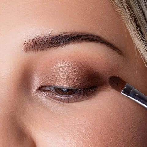 Darker shadow being applied to the corner of the model's eye. 