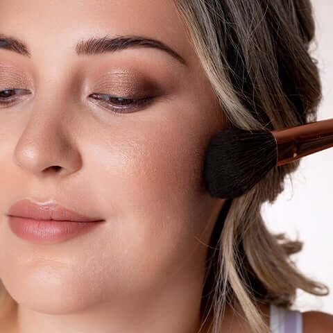 Bronzer being applied to model's face.