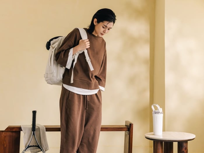 單肩背著 Bagsmart 旅人機能擴充後背包 38L 獨家新色(白色款)進行運動休閒穿搭,展現機能包融入網球、日常生活的輕裝美學,滿足 PTT 與 Dcard 網友對「旅行後背包」與高顏值「女後背包推薦」的泛用性期待。
