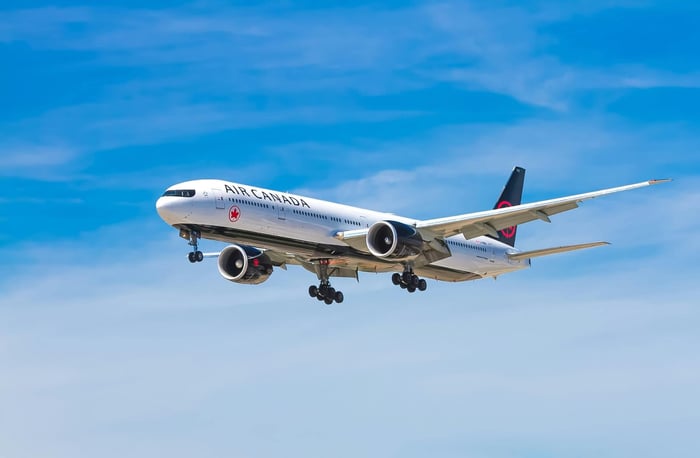 藍天中飛行的民航客機,為旅客解答出國搭飛機時「背包算手提行李嗎」的隨身手提行李尺寸與重量限制。