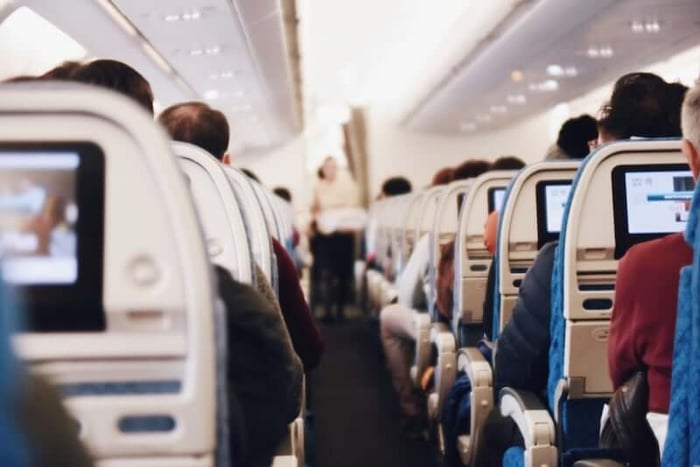 飛機客艙內乘客座椅與走道畫面,解析出國旅遊時「可以帶兩個後背包上飛機嗎」的航空公司登機件數限制。