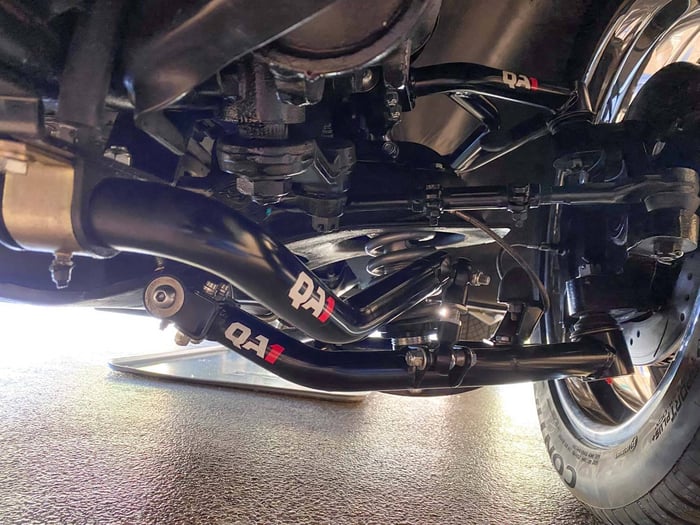 Underbody shot of the front suspension showing QA1 tubular control arms and sway bar.