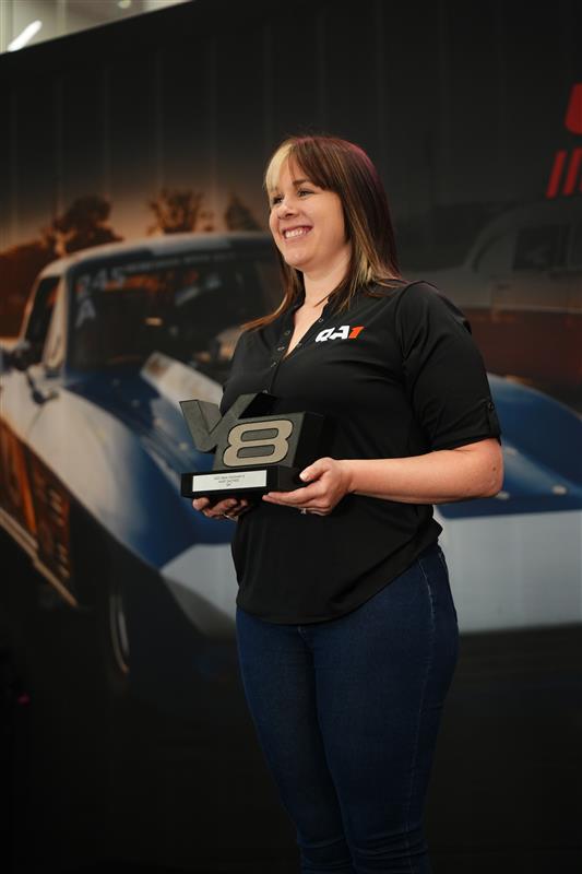 Women in QA1 shirt holding award