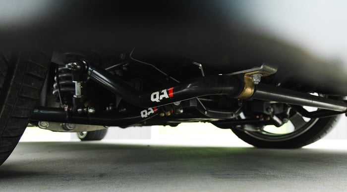 Front QA1 tubular crossmember, sway bar, and coilovers installed on stock chassis.