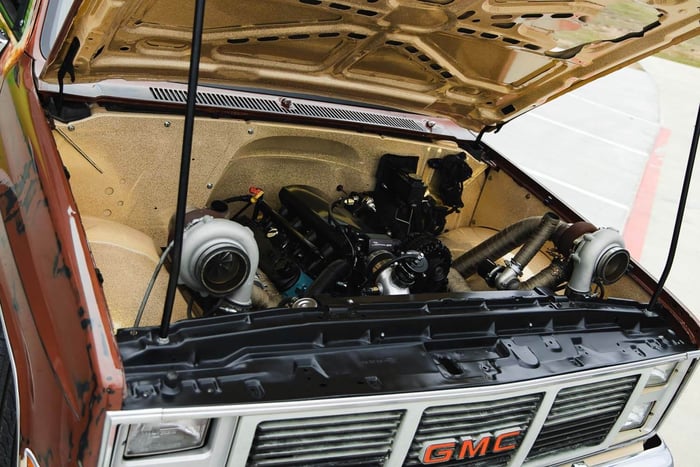 Front 3/4 view of the JourneyHQ 1983 GMC C10 showing patina paint and turbo hood cutouts.