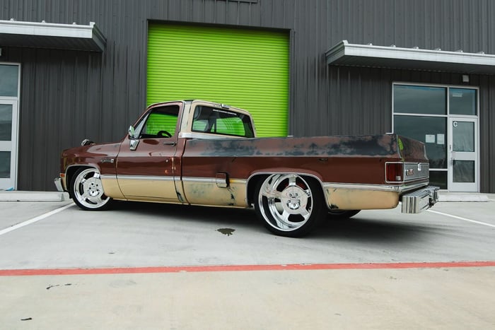 Rear angle of the JourneyHQ C10 showing the custom JTX 24x12 wheels and gas door exhaust.