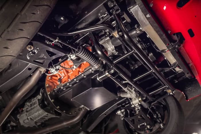 Under-car view of QA1 front coilovers and rack-and-pinion setup.