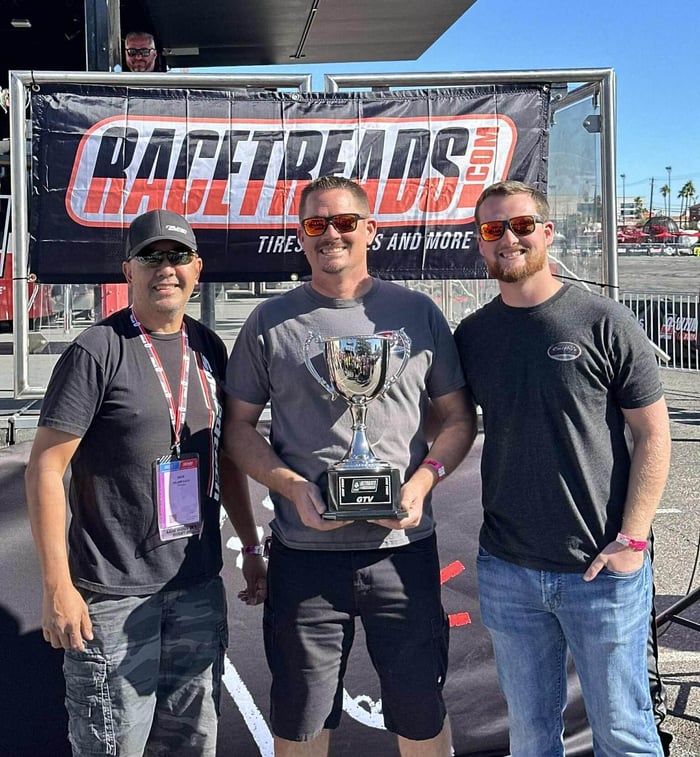 Three men holding awards