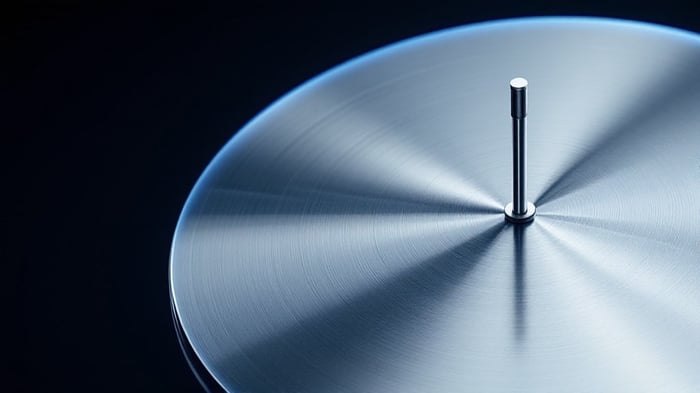 Quarter-wave monopole antenna mounted at the center of a circular metal ground plane disc with radial reflections under cool studio lighting
