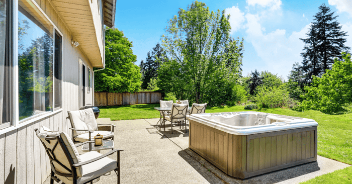 small hot tub on backyard concrete floor