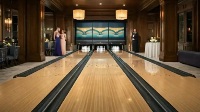 A luxurious, carpeted bowling alley, complete with sleek wooden lanes, is a centerpiece of a lavish home hosting a lively party. Guests in elegant attire are enjoying the evening, bowling and laughing.
