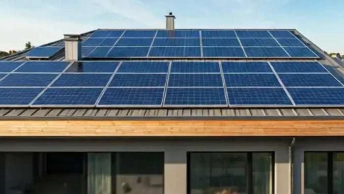A modern house with a flat roof, entirely covered in photovoltaic solar panels.