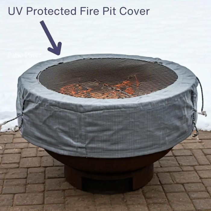A large, round fire pit covered with a gray, UV-protected cover.