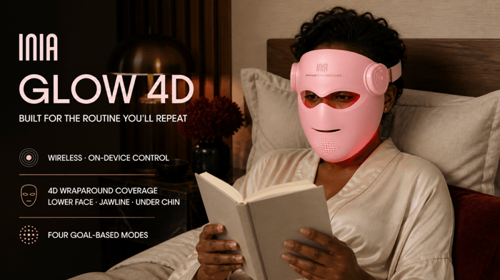 Woman using the wireless INIA GLOW 4D LED mask while reading in bed