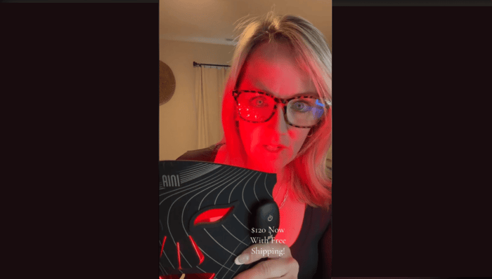A woman shows off a facial device