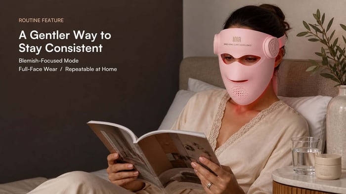 Woman wearing the pink INIA GLOW 4D LED mask as part of an at-home skincare routine