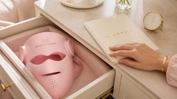 Pink INIA GLOW 4D mask beside a notebook used to track weekly sessions