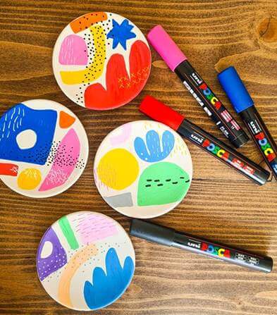 A group of colorful painted plates and markersAI-generated content may be incorrect.