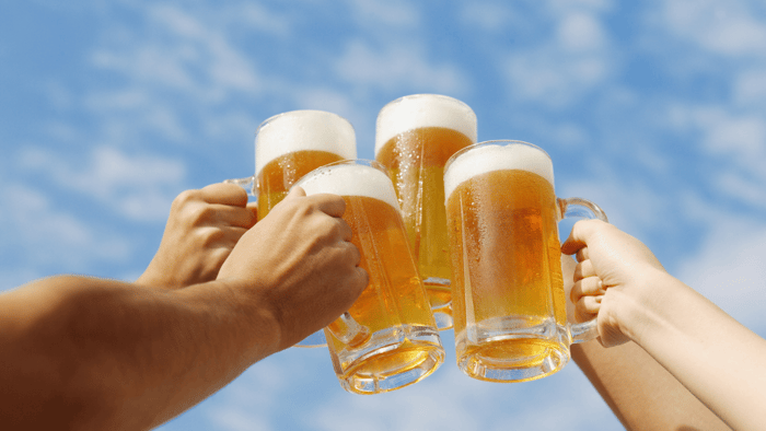 Mugs of craft beer raised in a toast, representing a blog post about the best Colorado brewery experiences.