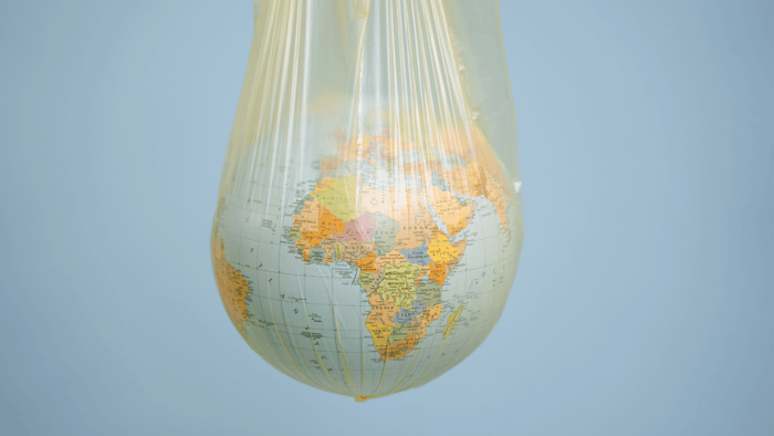 Globe in plastic bag symbolizing Plastic Free July and the push for a plastic-free future