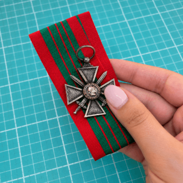 Hand holding out medal and ribbon for mounting